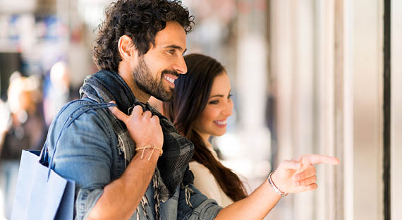 Young smiling couple shopping in an urban street  Shallow depth of field, focus on the man